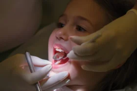 Close up of dentist examining young patient.