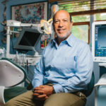 Dr Edward Zuckerberg sits in a dental surgery.