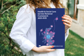 A woman holds up the cover of the new Scottish Government Health and Social Care Framework.