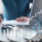 A bar chart graph is overlaid on an image of a mann using a laptop and a calculator.