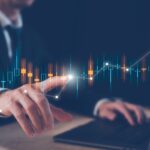 An illustration of data overlaid on a picture of a suited office worker at his laptop.