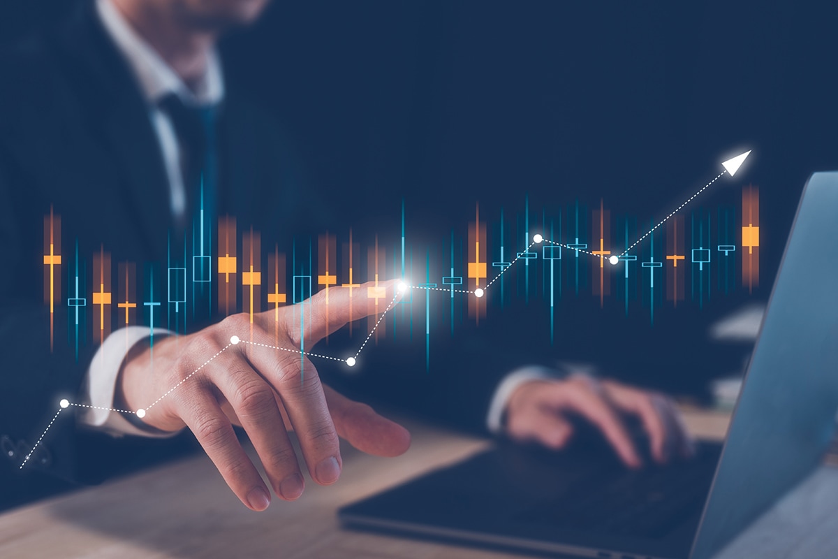 An illustration of data overlaid on a picture of a suited office worker at his laptop.