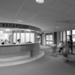 A black and white atmospheric image of a medical reception desk