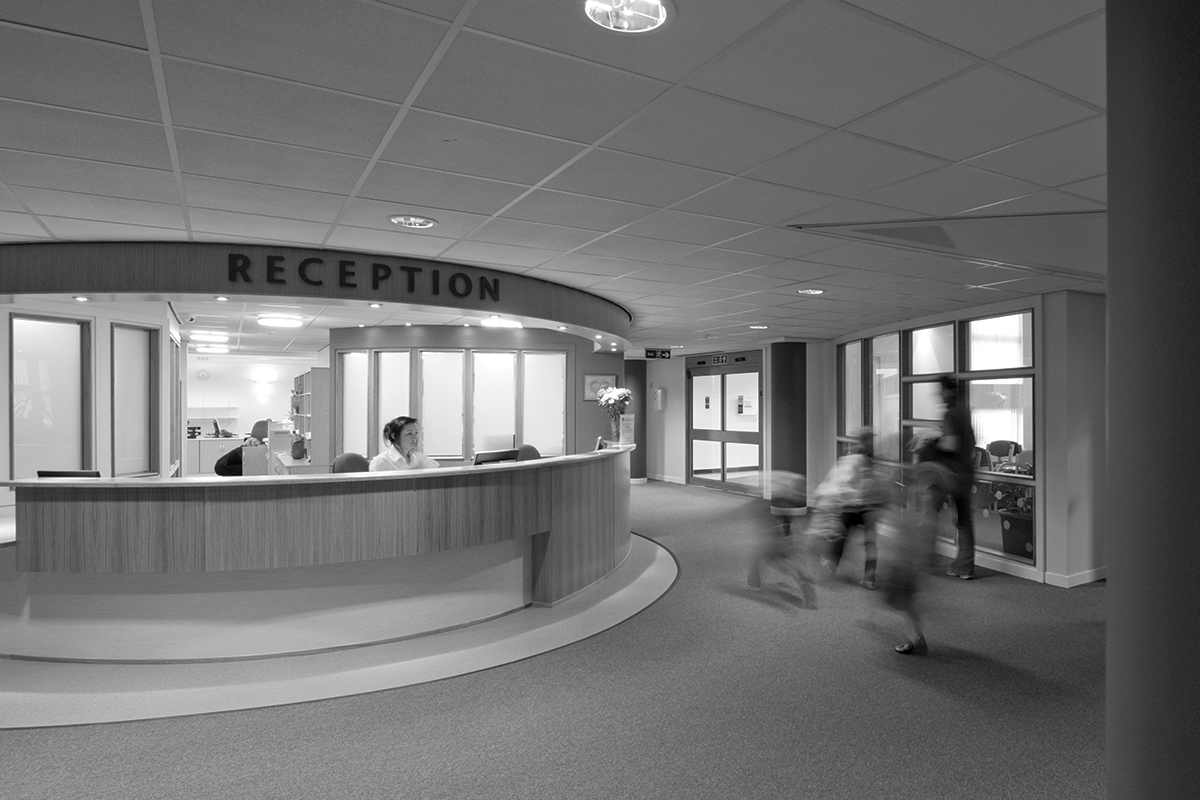 A black and white atmospheric image of a medical reception desk