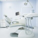 An empty dentist's chair in the middle of a brand new modern surgical room.