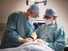 Two dental surgeons work on a patient proceedure.
