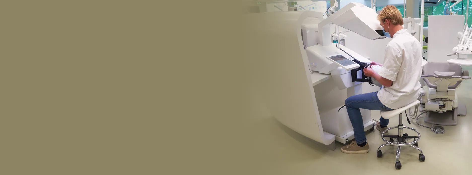 Dental student using a haptic simulation system to practise clinical skills in a modern dental teaching environment.